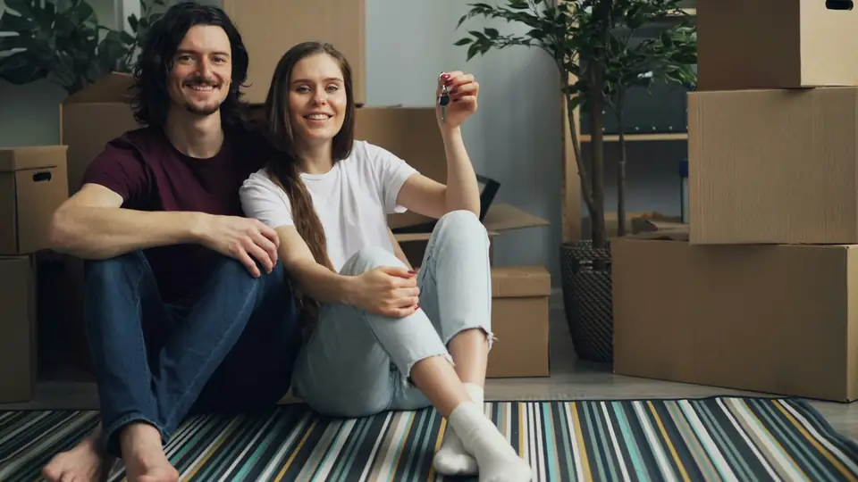 Couple sitting on the floor among moving boxes