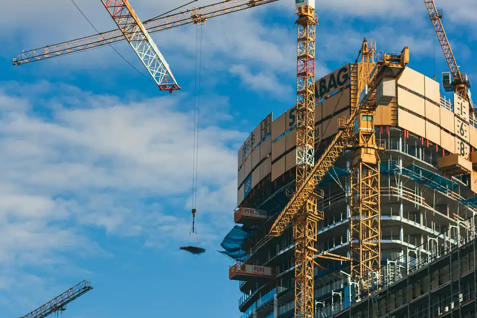 Construction cranes around a new residential tower