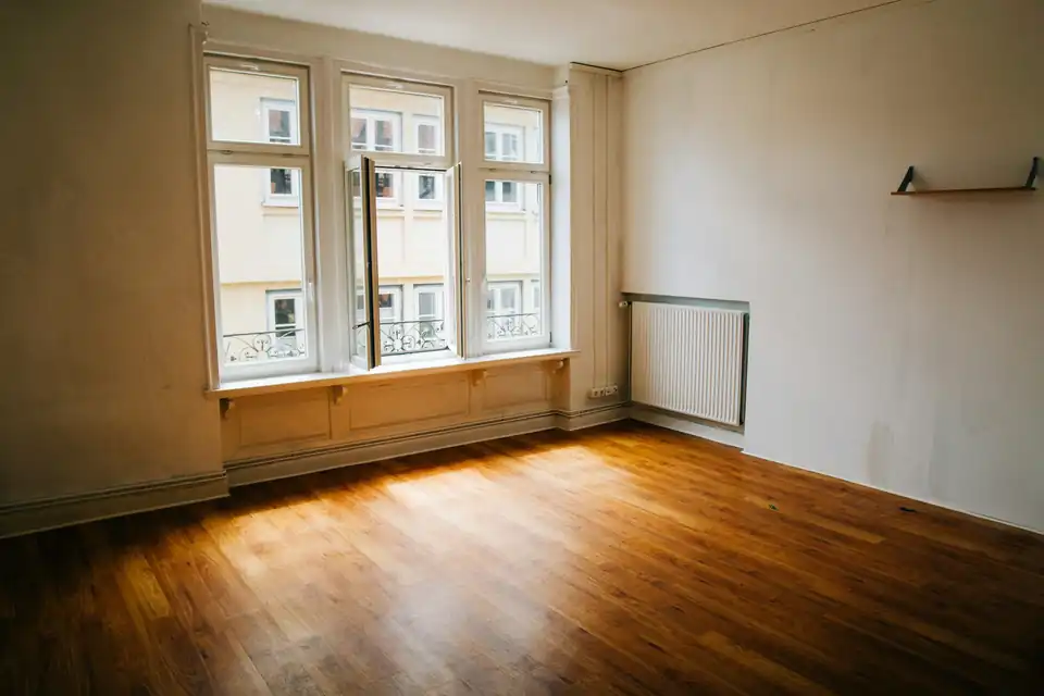 Empty apartment with wooden floor and large windows