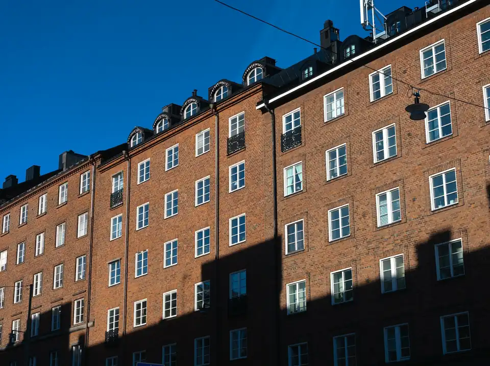 Brick apartment building facade under a blue sky