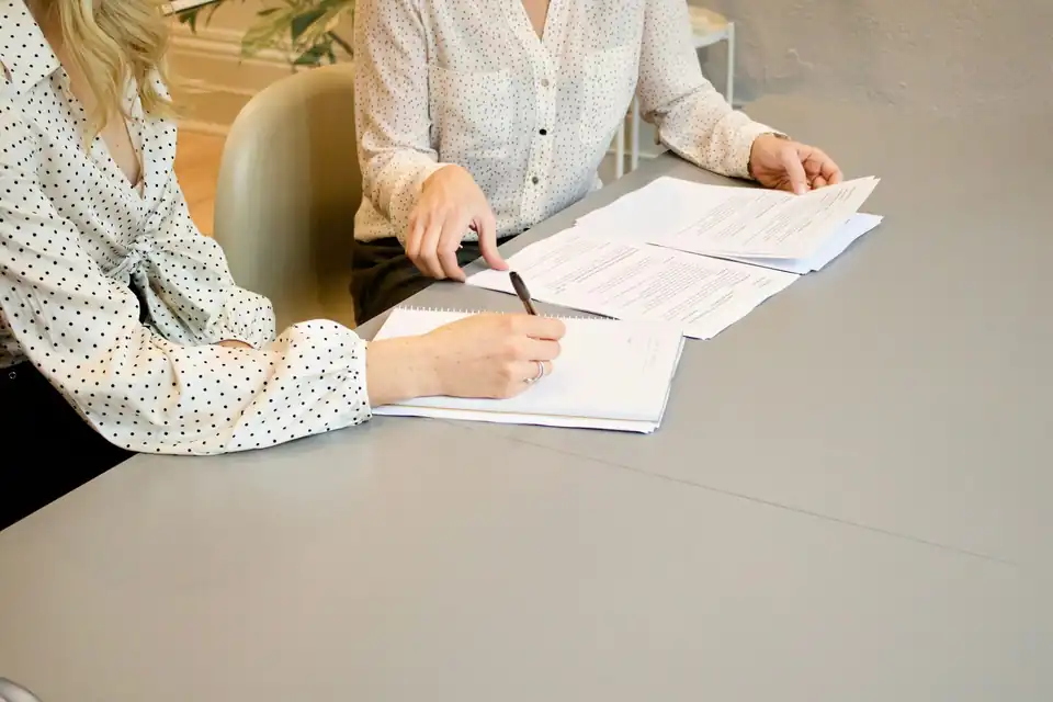 Two people filling in paperwork at a table