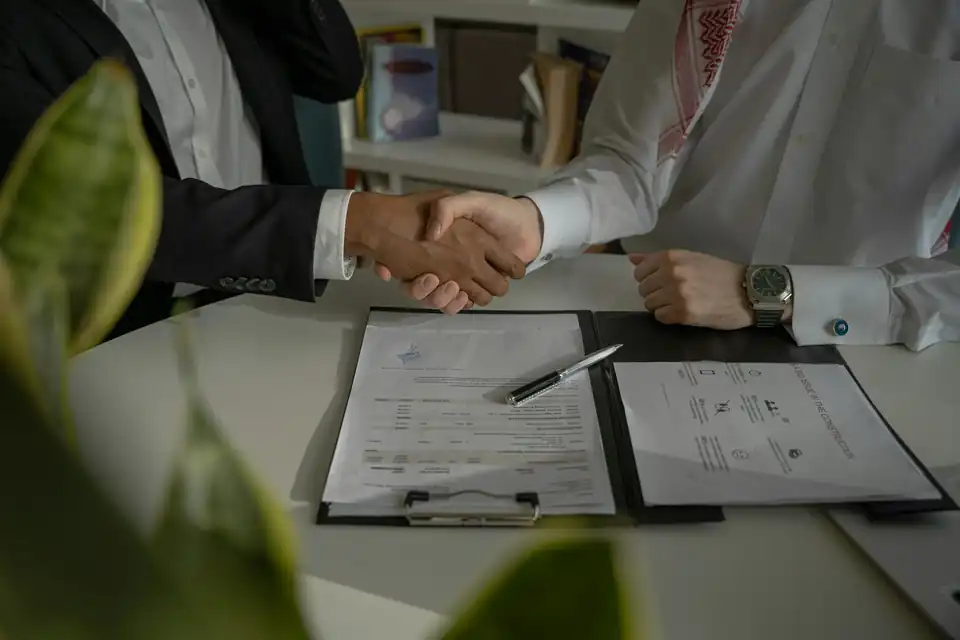 Handshake over documents on a desk