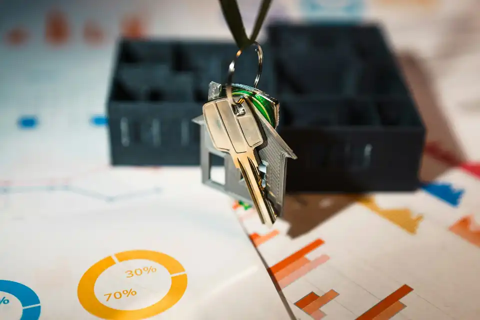 House keys hanging over financial charts