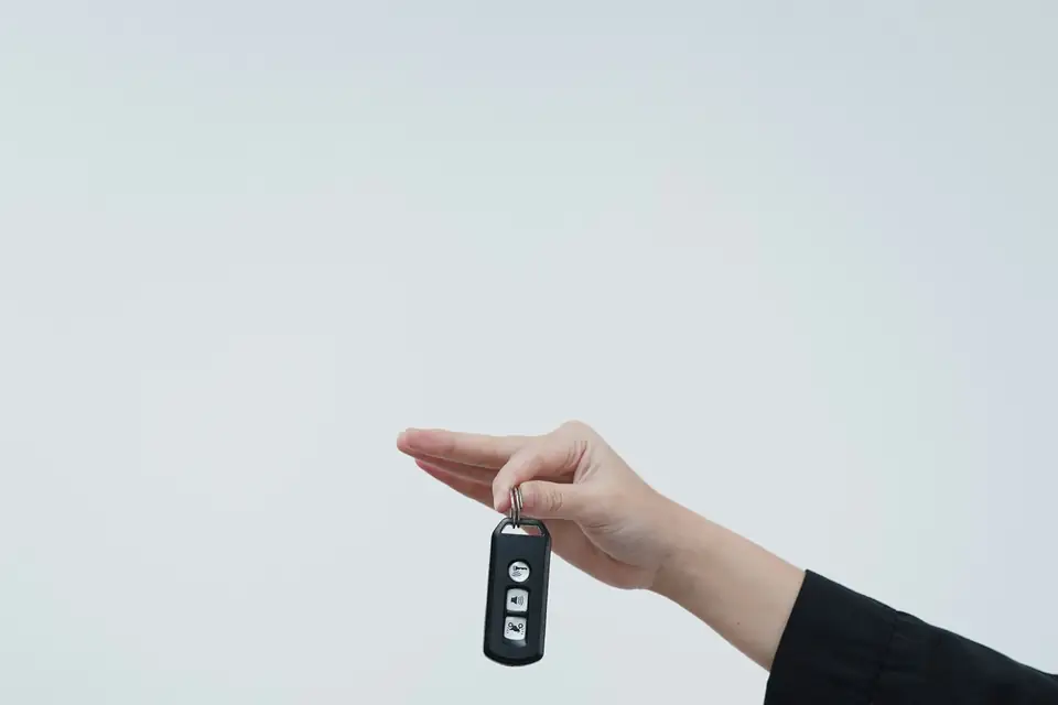 One hand passing car keys to another