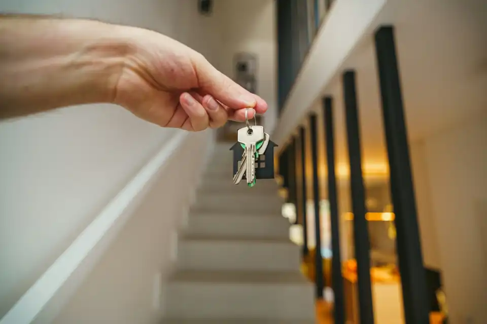 Hand holding keys on a staircase