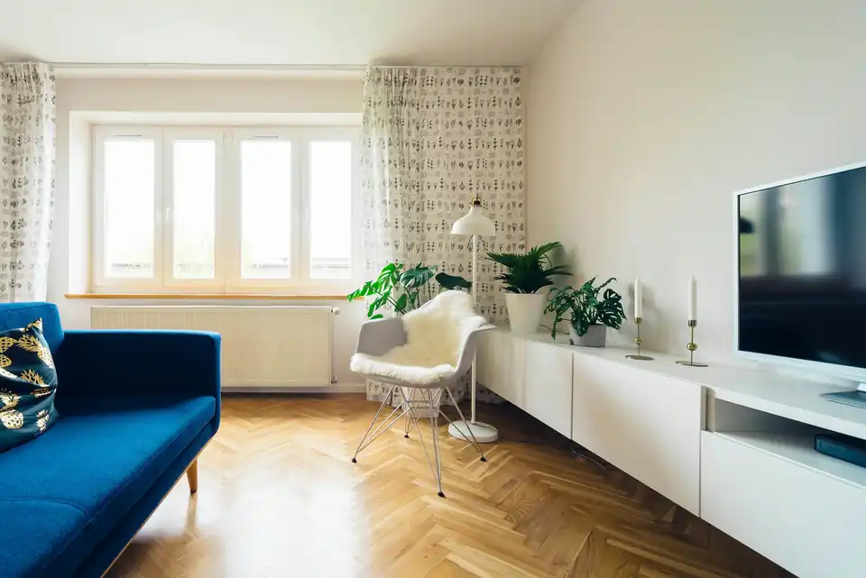 Bright living room with a blue sofa and parquet floor