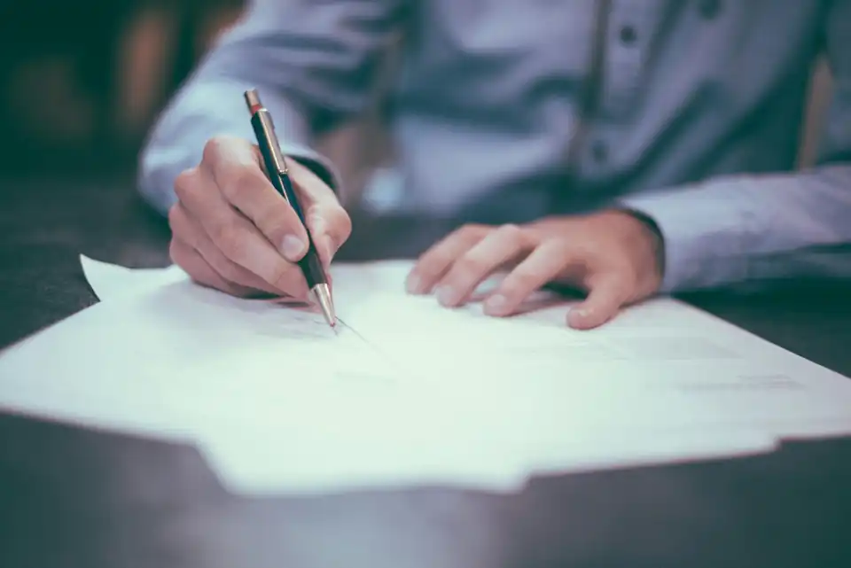 Man signing a document with a fountain pen